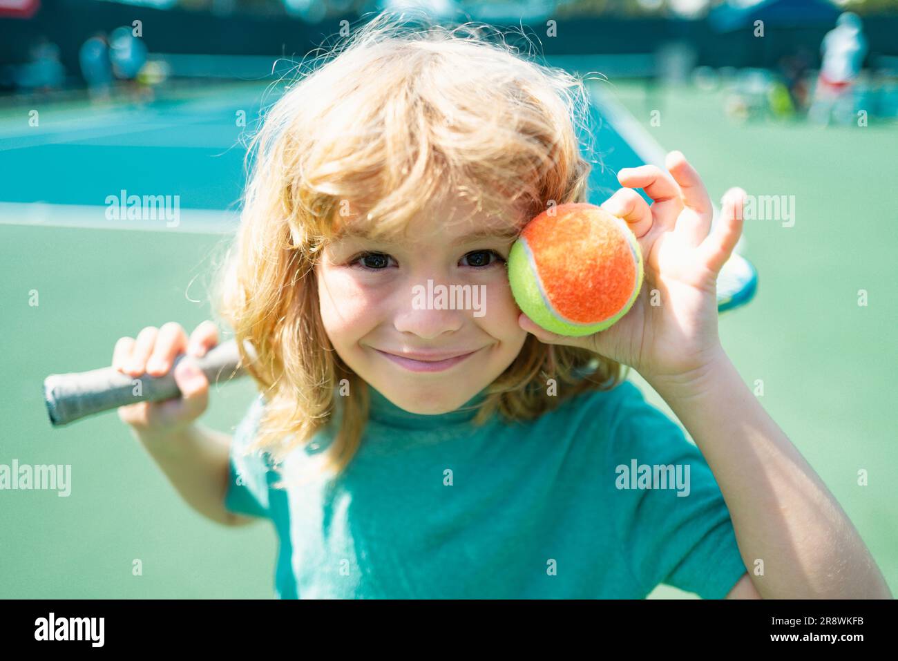 Child with tennis racket and ball on tennis court outdoor. Sport ...