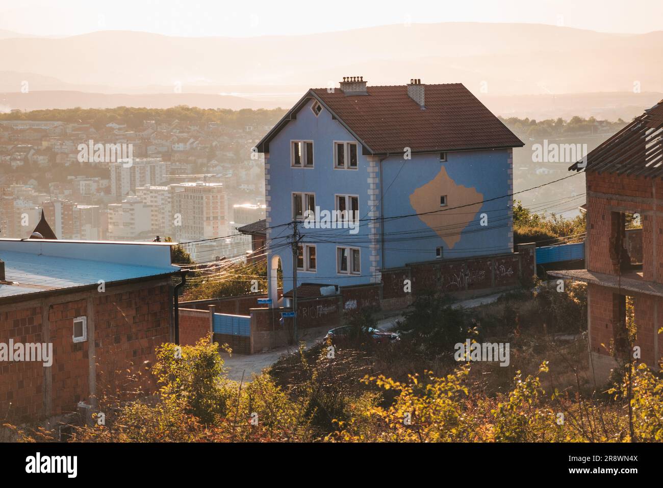 a patriotic house with a map of Kosovo in the national colors painted on its side, atop a hill in the capital city of Pristina Stock Photo