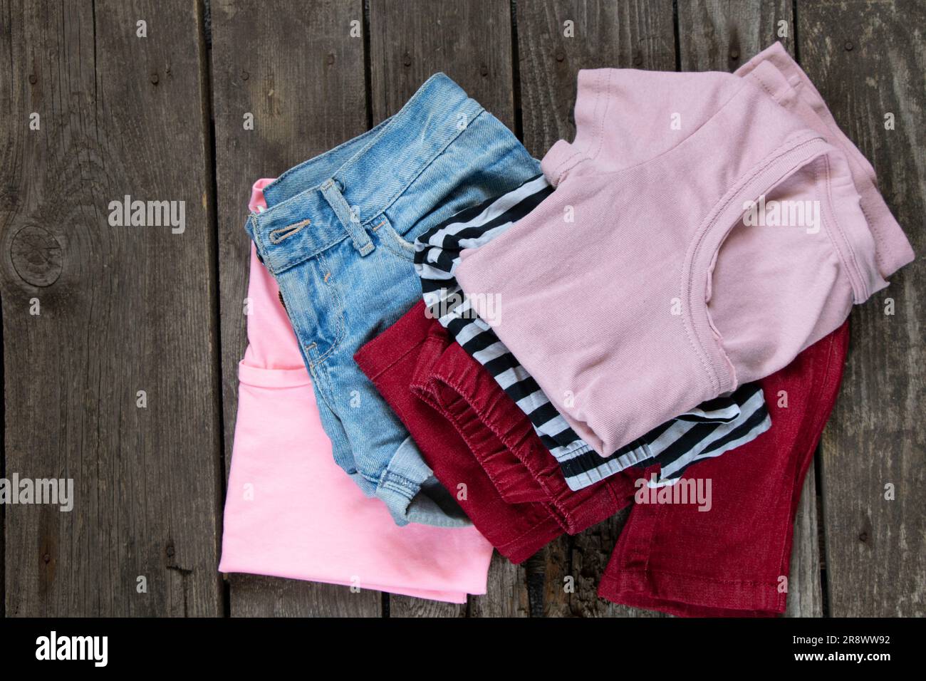 womens t-shirt and denim shorts lay on rustic brown background, womens clothing, fashion, many womens things Stock Photo