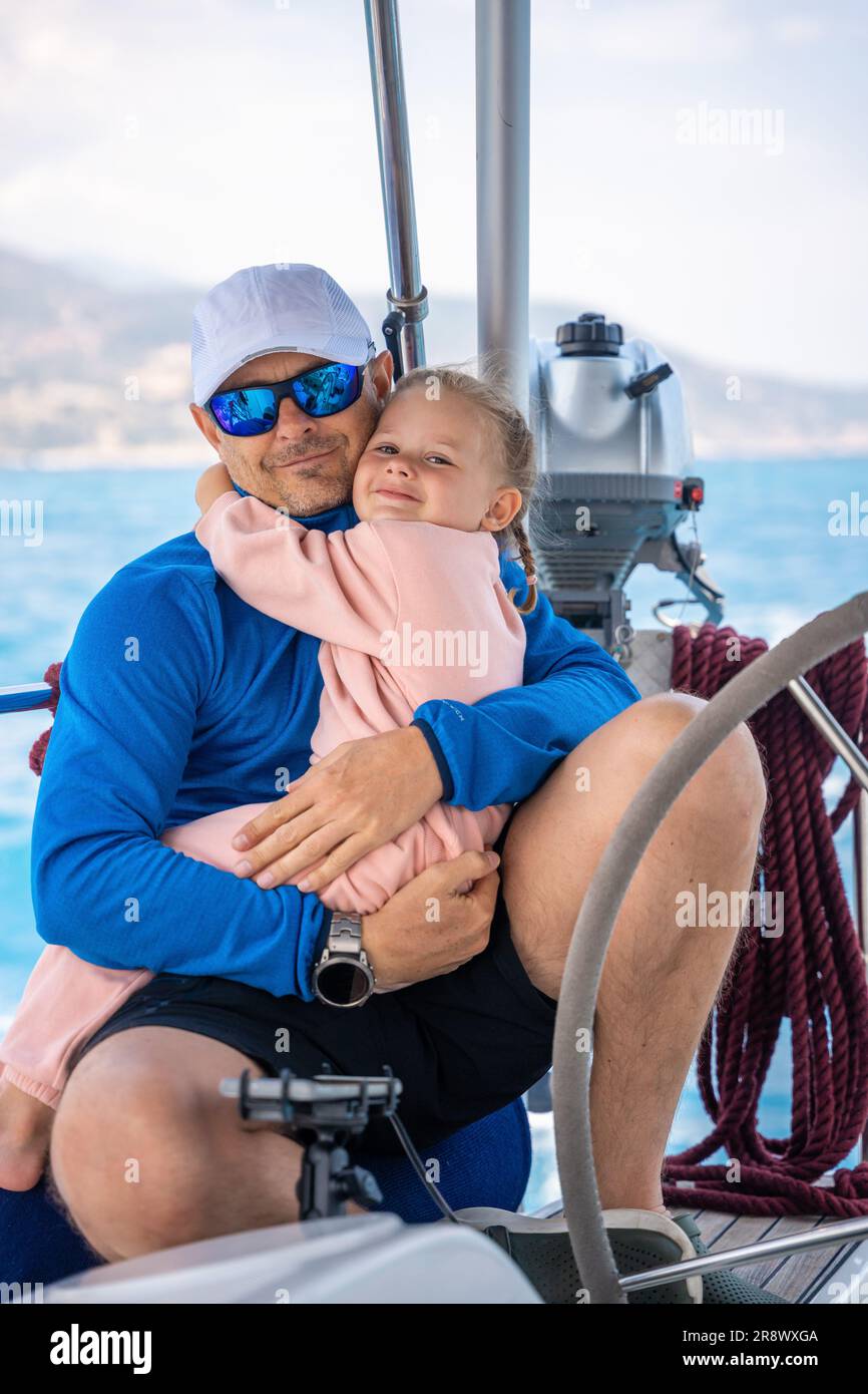 Father and daughter control sailing boat in the sea on boat or yacht