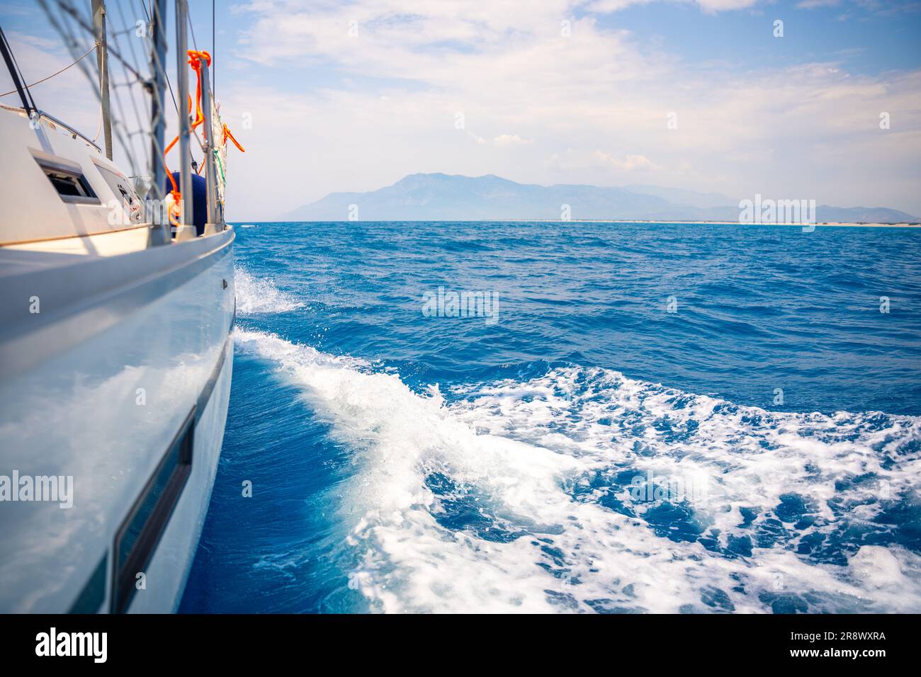 Yacht sailing in an open sea. Close-up view of side of the boat. Clear ...
