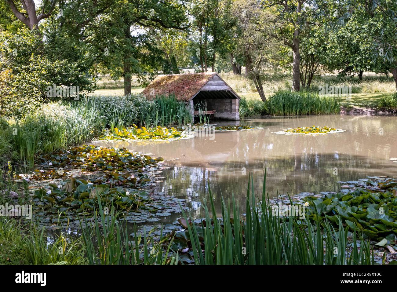 Boat house on a lake in an English country garden in summer Stock Photo