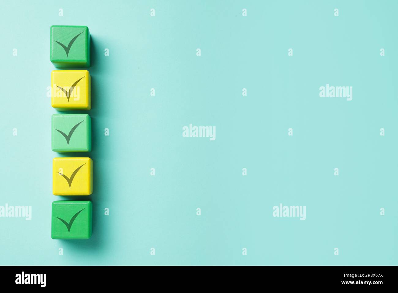 Cubes with check marks on turquoise background, top view. Space for ...