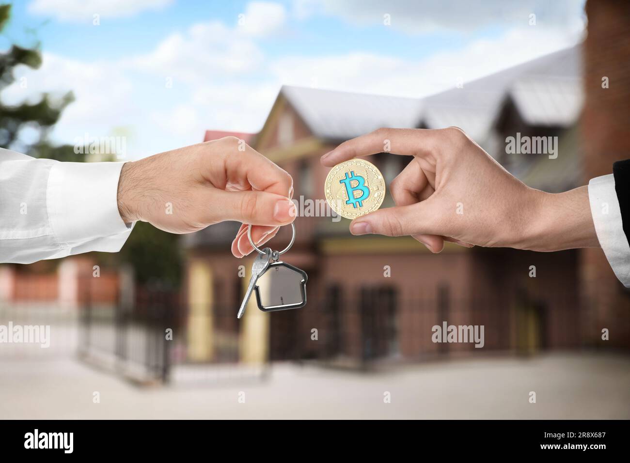 Bitcoin exchange. Man using cryptocurrency to buy house. Seller holding key  and buyer with bitcoin indoors, closeup Stock Photo - Alamy