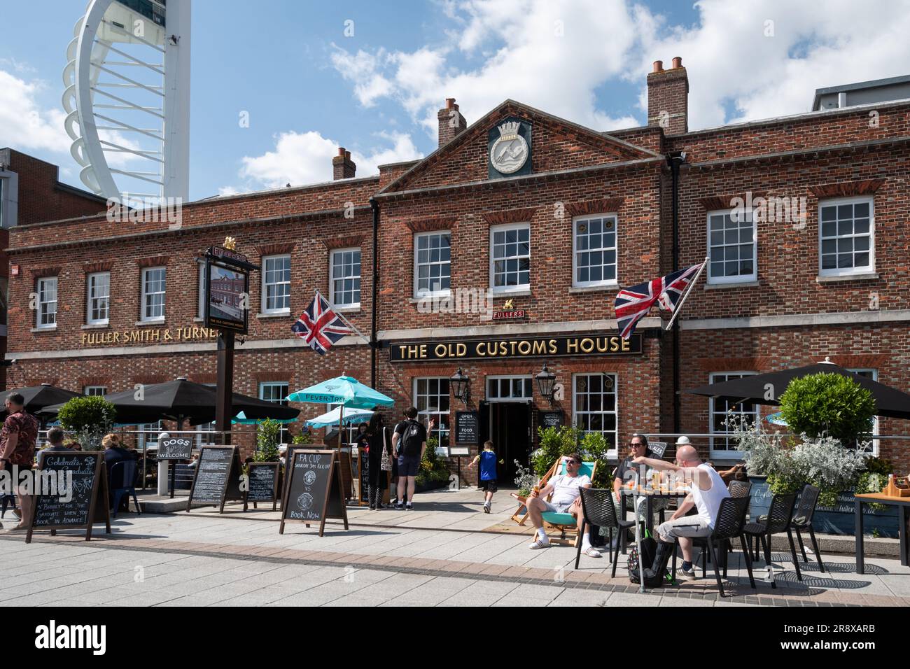 Gunwharf Quays in Portsmouth on a sunny summer June day with people sitting outside the Old Customs House pub, Hampshire, England, UK Stock Photo