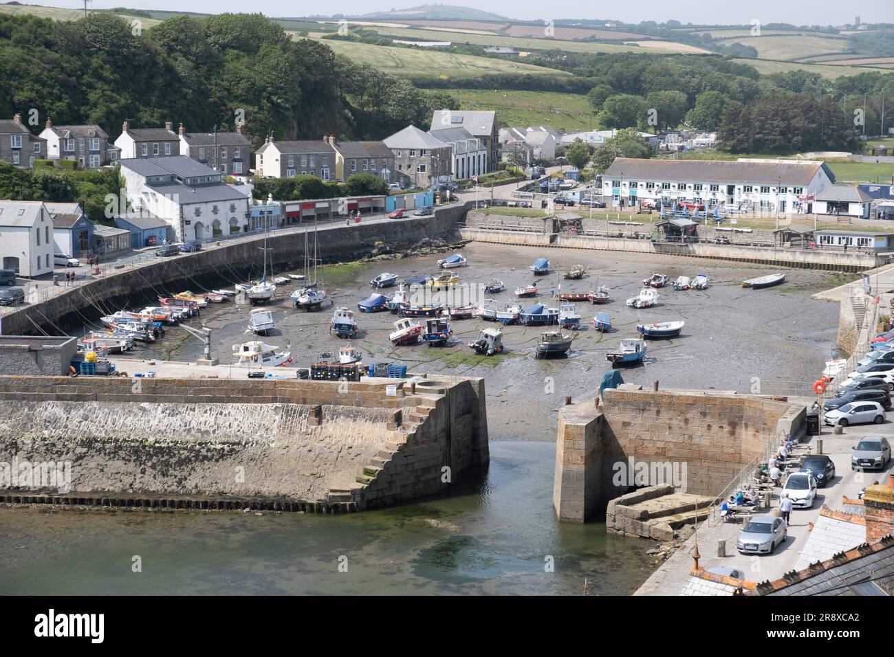 View of the harbour at Porthleven in Cornwall, England with fishing boats at low tide. Stock Photo