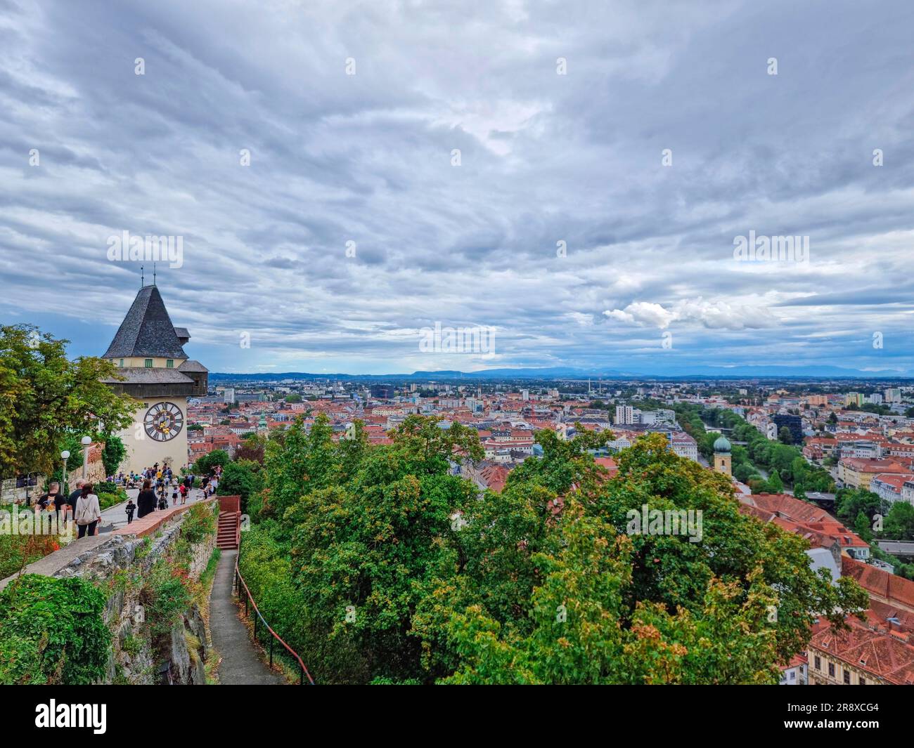 Cityscape of old town of Graz and the Clock Tower (Grazer Uhrturm), famous tourist attraction in Steiermark, Austria, in cloudy day Stock Photo