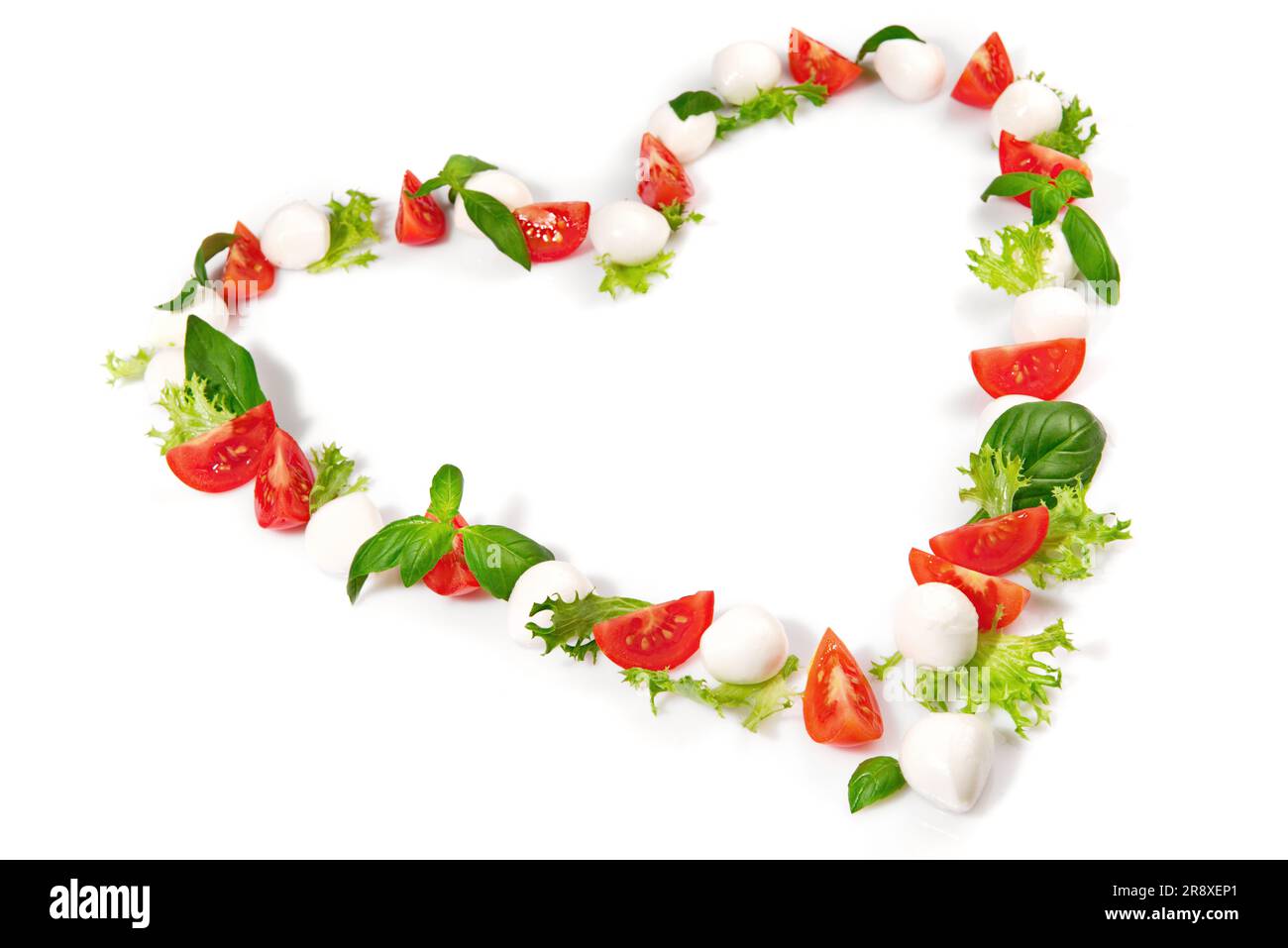 Tomato Mozzarella Heart Shape with Basil isolated on white Background Stock Photo