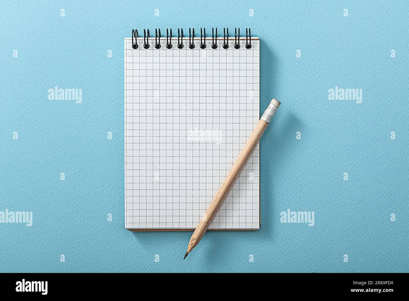 Notepad And Wooden Pencil On Blue Background Stock Photo