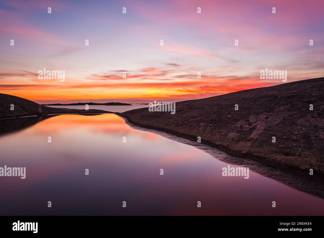 Coastal sunset in Gothenburg, Sweden: tranquil ocean reflection, peaceful afterglow. Stock Photo