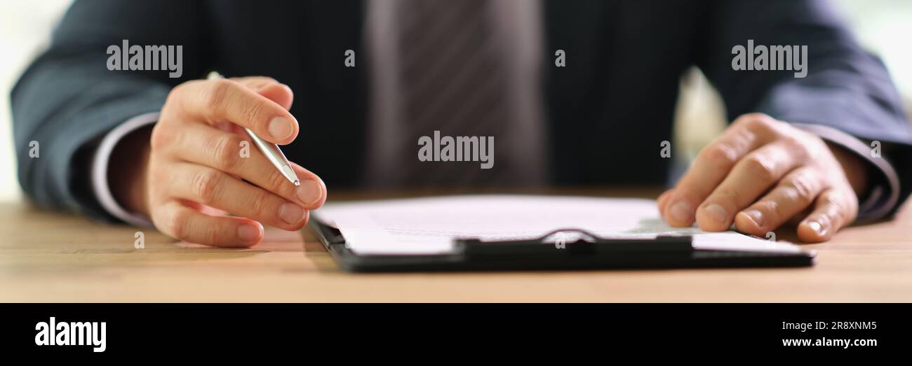 Businessman studying information on document before signing at work in office closeup Stock Photo