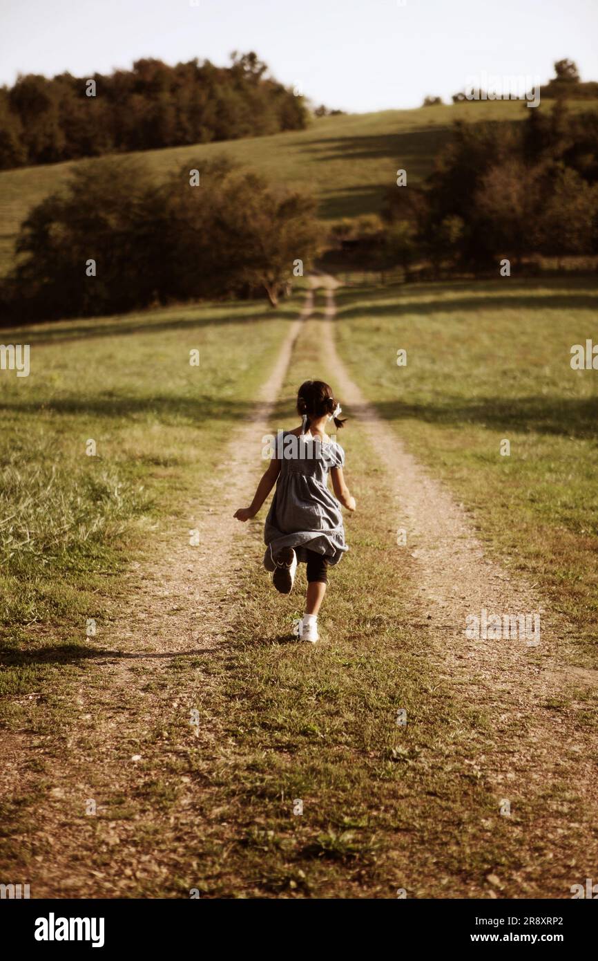 A young girl running down a country road in Frankenstein, Missouri