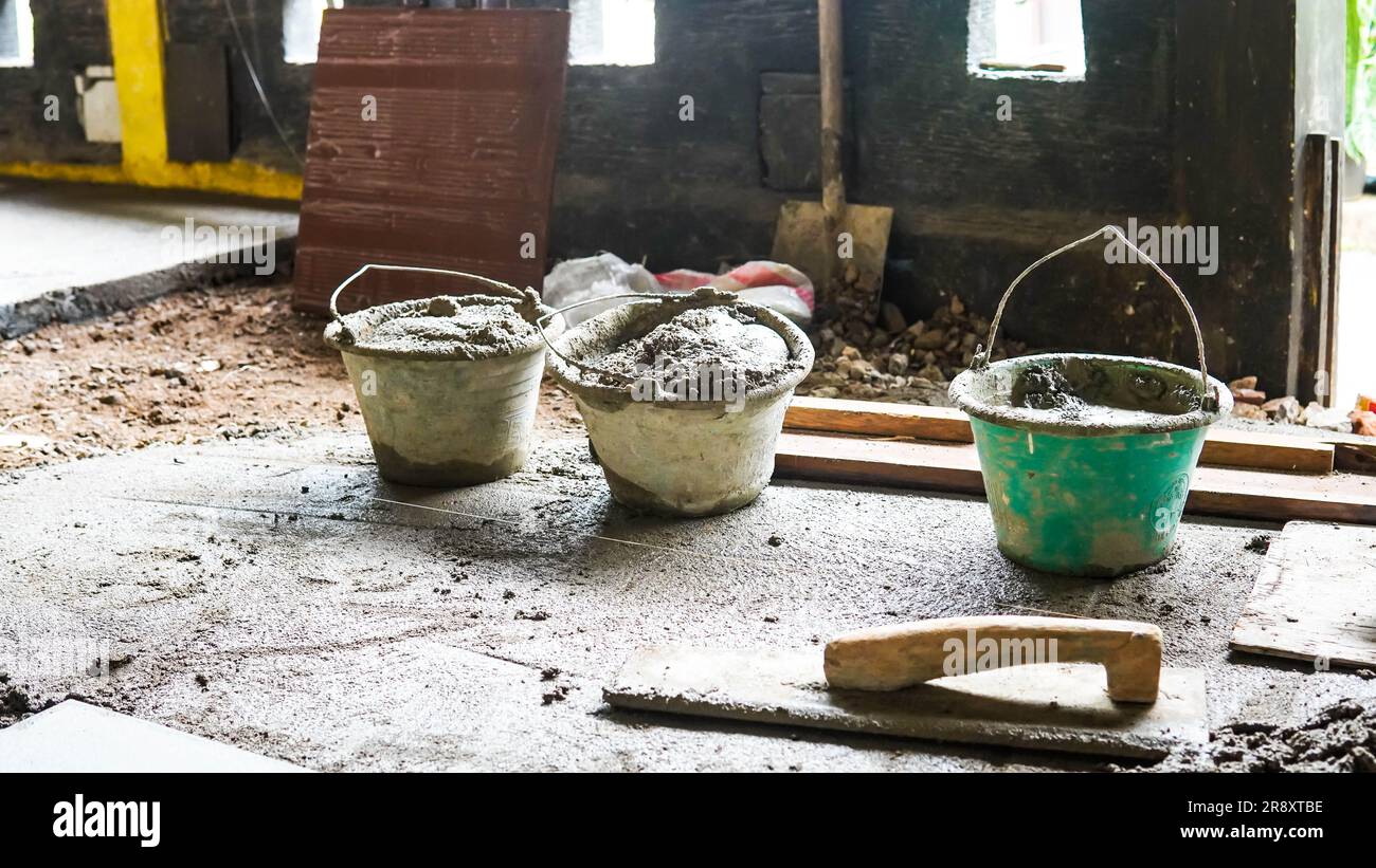 A male construction worker installs a large ceramic tile Stock Photo