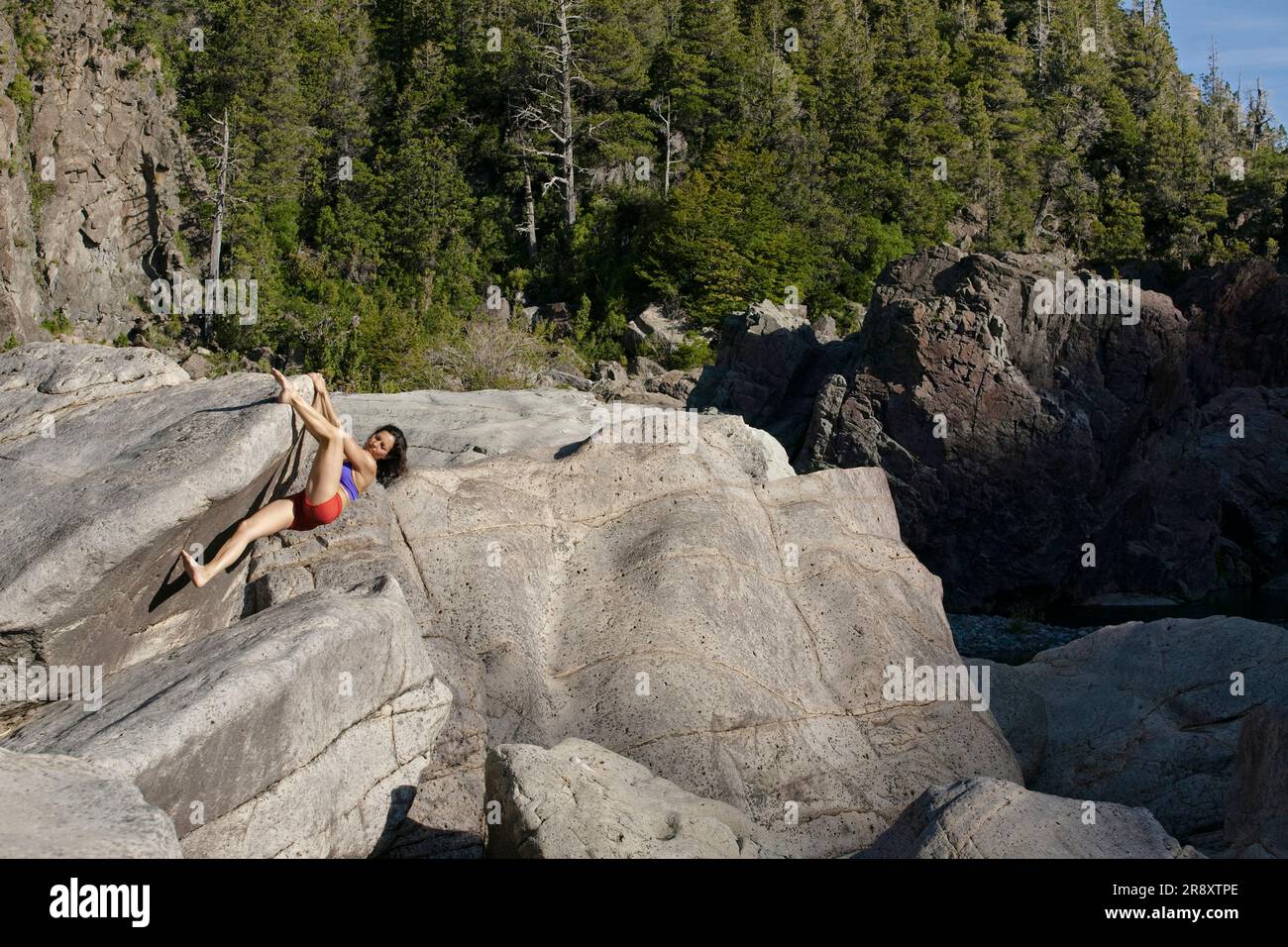 A woman bouldering barefoot at the Los Alerces National Park, Chubut
