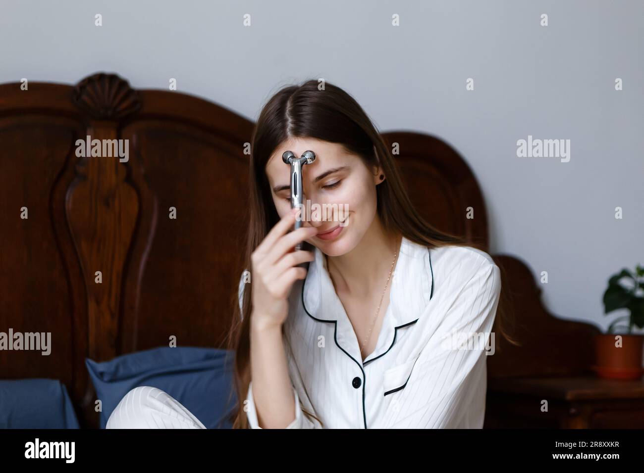 woman takes care of facial skin with cosmetics and massagers Stock Photo
