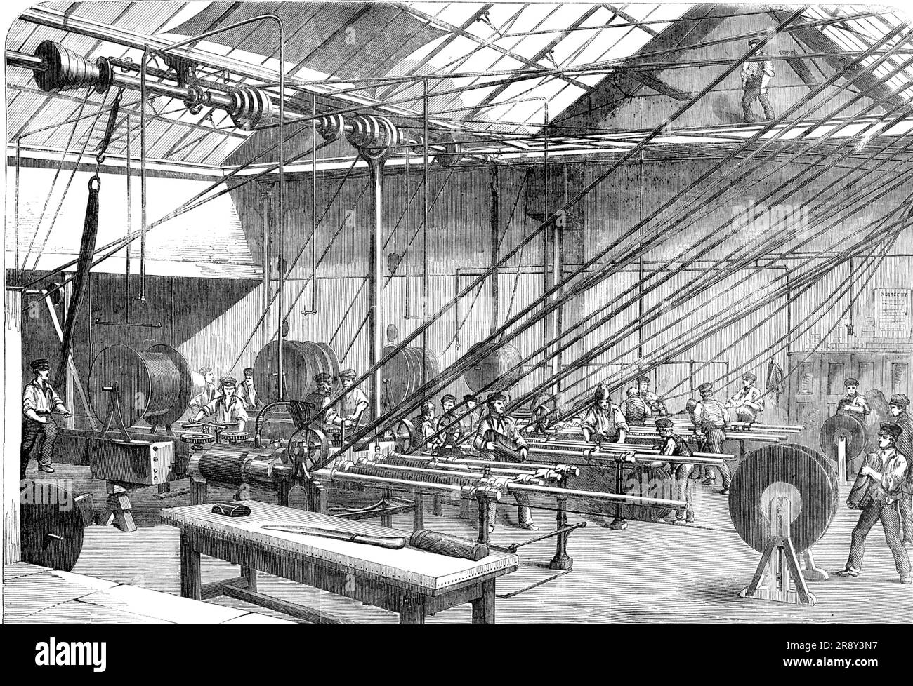 Machines covering with Gutta Percha the Atlantic Cable Wire, at the Gutta Percha Company's Works, Wharf-Road, [London], 1857. 'The core is composed of seven copper wires...wound spirally together so as to form a strand or cord; the object of this arrangement, instead of a single wire of the same sectional area, being to provide against the possibility of any break of continuity taking place in the metal. This strand...is covered with three layers of the purest gutta percha, separately applied, in the manner usual with telegraphic wire. The core thus formed by the treble covering of gutta perch Stock Photo