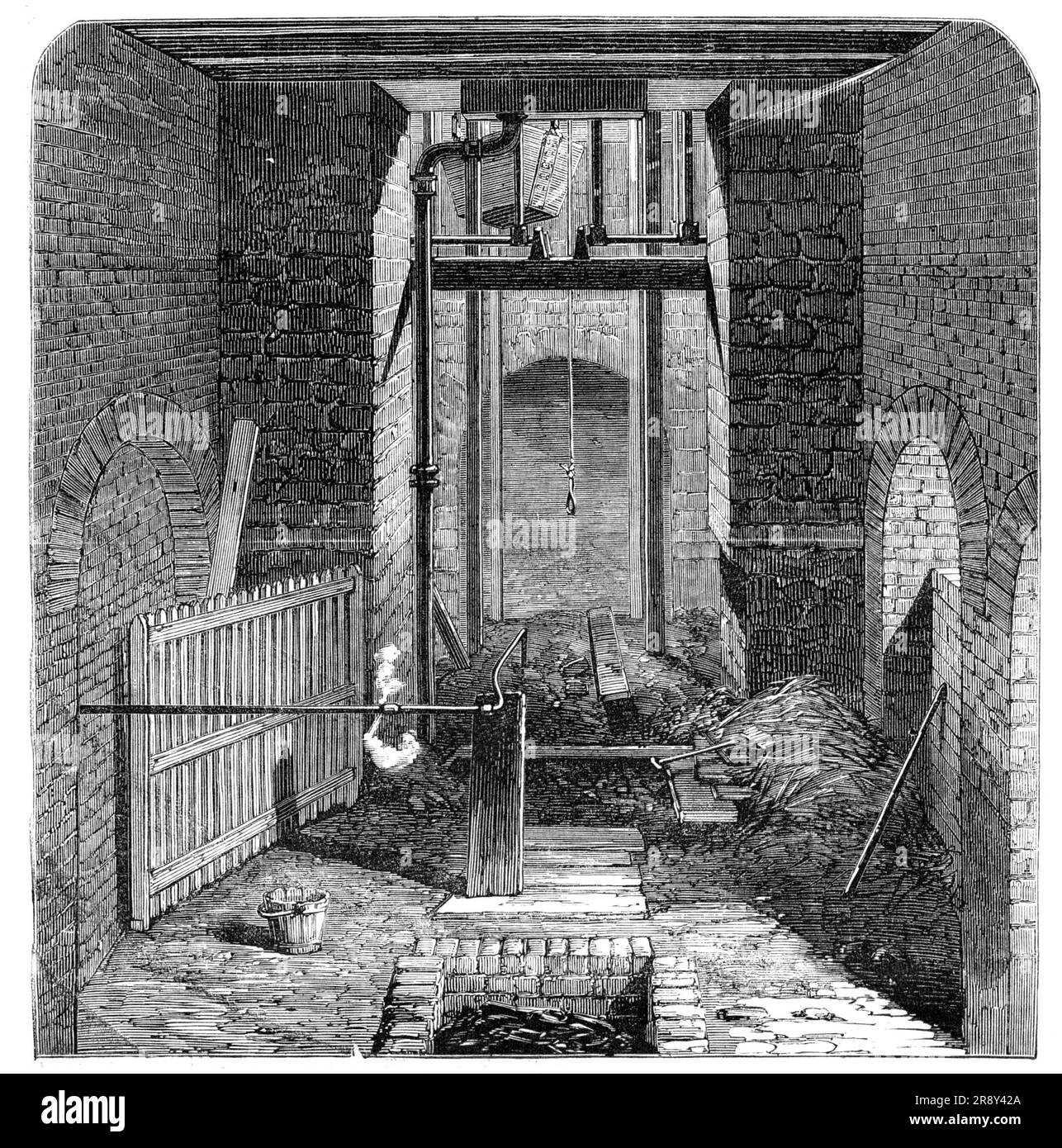 The Lund Hill Colliery Explosion: Mouth of the Downcast Shaft, 1857. Preparations to recover bodies after mining disaster in Barnsley. 'The Illustration represents the entrance to the downcast shaft, after the mouth had been closed. The iron basket in which the miners made their descent is suspended immediately over it, and a jet of steam is being forced through a pipe connected with the boiler into the pit, for the purpose of extinguishing the fire. The brick tank in the foreground of the sketch was filled with charcoal, preparatory to making carbonic acid gas, for the same purpose; but these Stock Photo