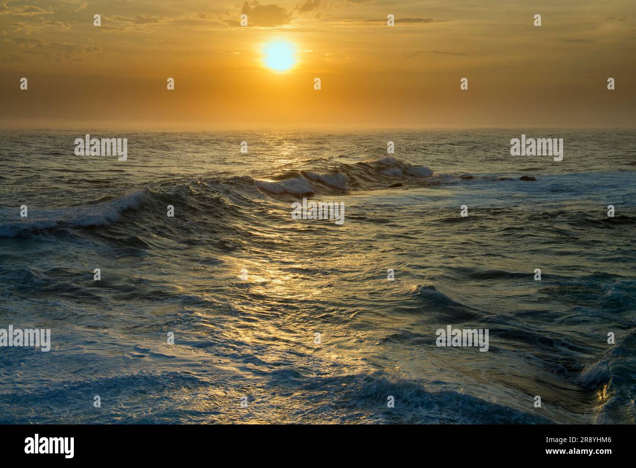 Senjojiki coast and the waves dyed by the rays of the setting sun Stock Photo