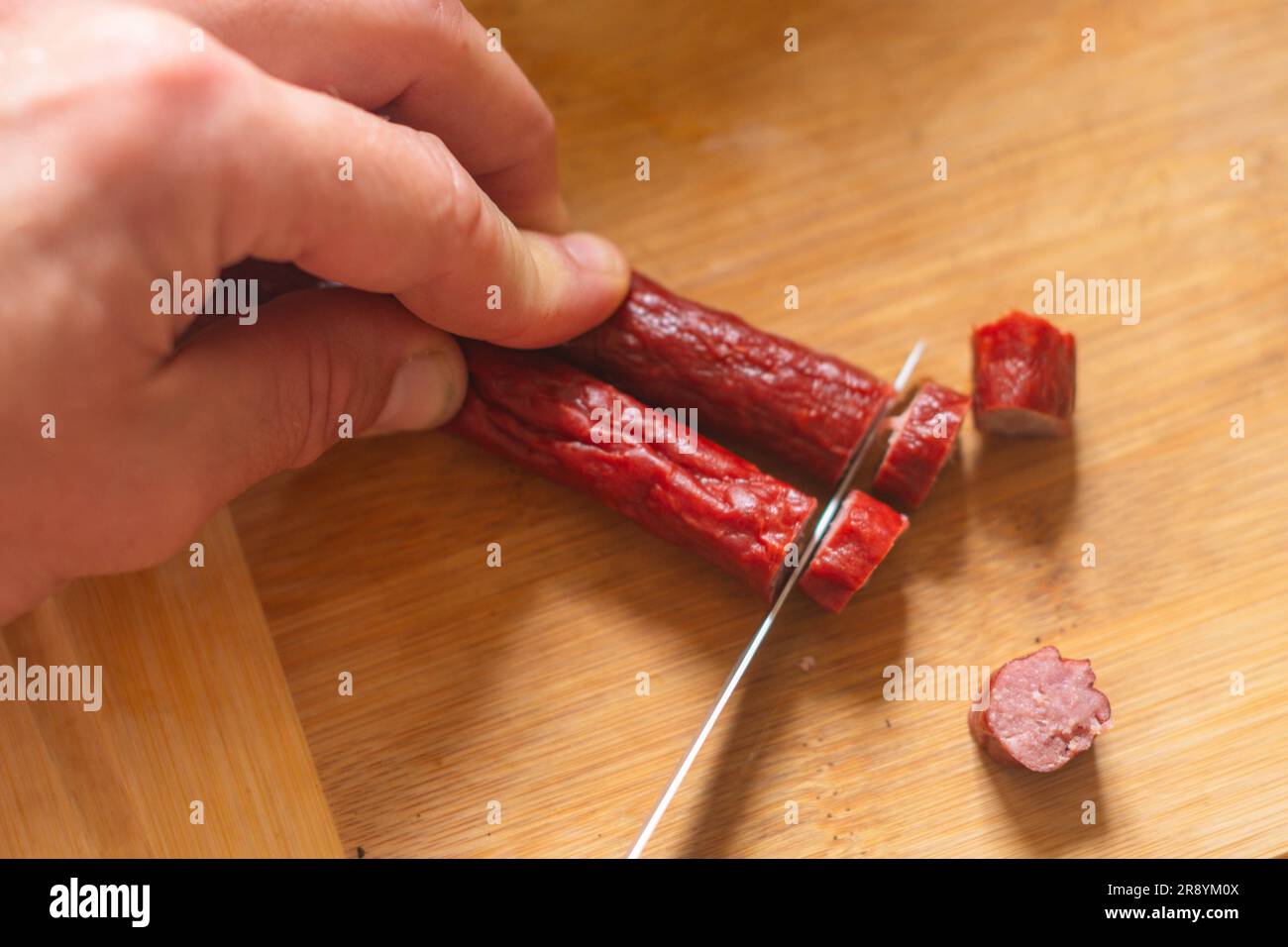 Cutting meat jerky sausage on cutting board top down perspective food breakfast cooking copy