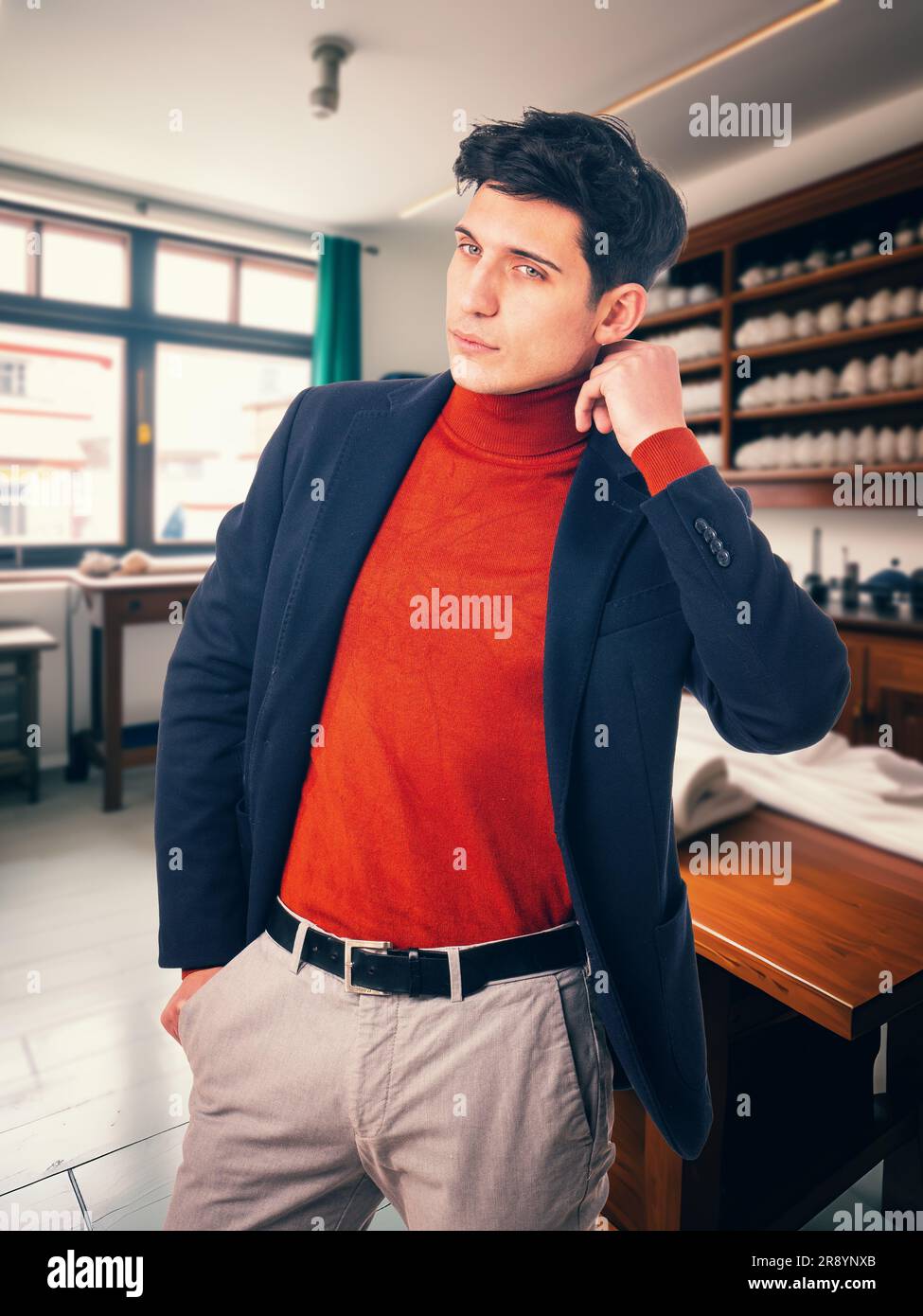 Handsome young man wearing suit in tailor shop Stock Photo - Alamy