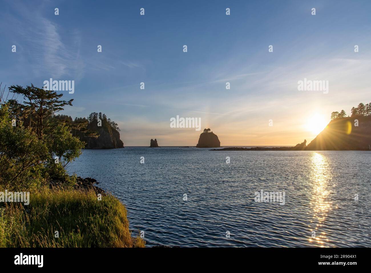Panoramic sunset view with lens flares of sun rays seen from the coastline of La Push, WA, USA with view on sea stacks and James Island and Little Jam Stock Photo