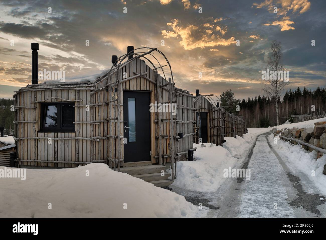 Jarvisydan Resort, Rantasalmi, Finland - Distinctive wooden lodges shot at sunset at the resort pictured in winter with snow on the ground Stock Photo