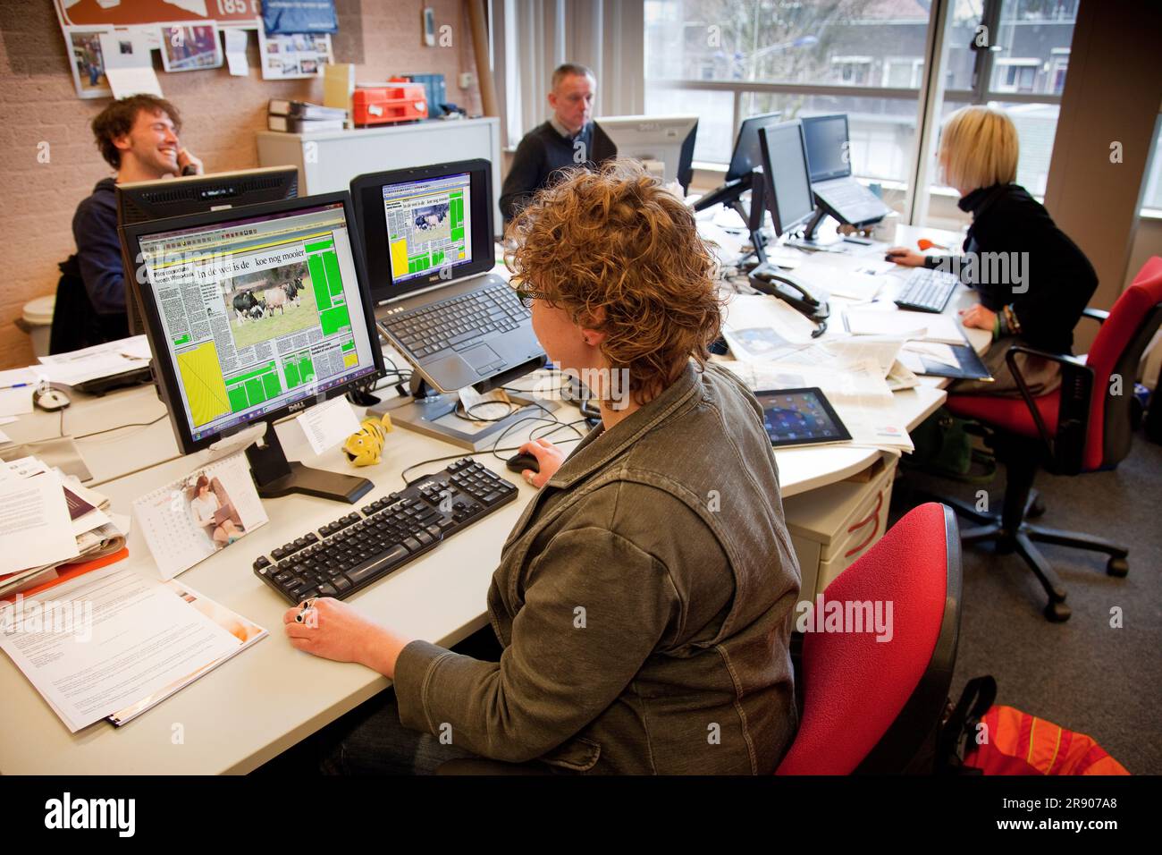 Netherlands, Doetinchem. a female journalist of newspaper 'Gelderlander' working at her desk. She writes articles and put them in the format LayOut of Stock Photo
