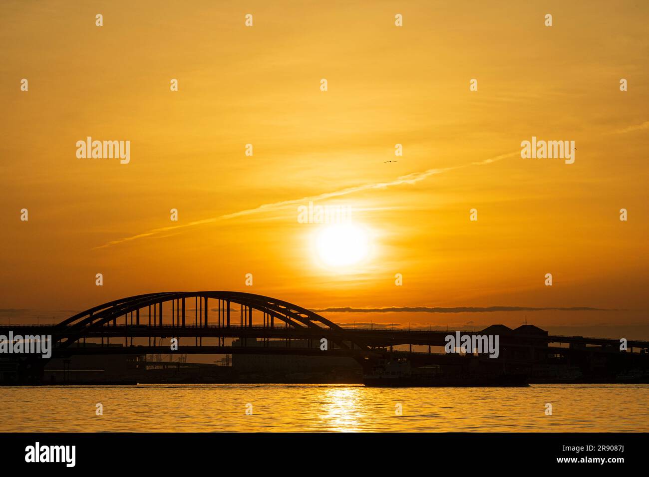 A vivid orange dawn sky and sunrise behind the silhouette of the double