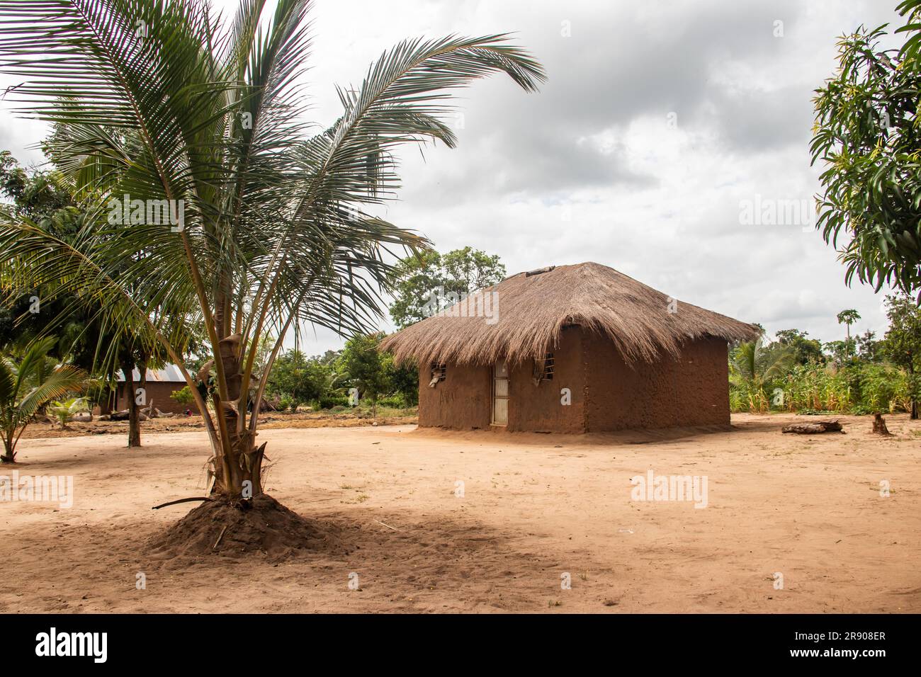 Typical rural mud-house in remote village in Africa with thatched roof, very basic and poor living conditions Stock Photo