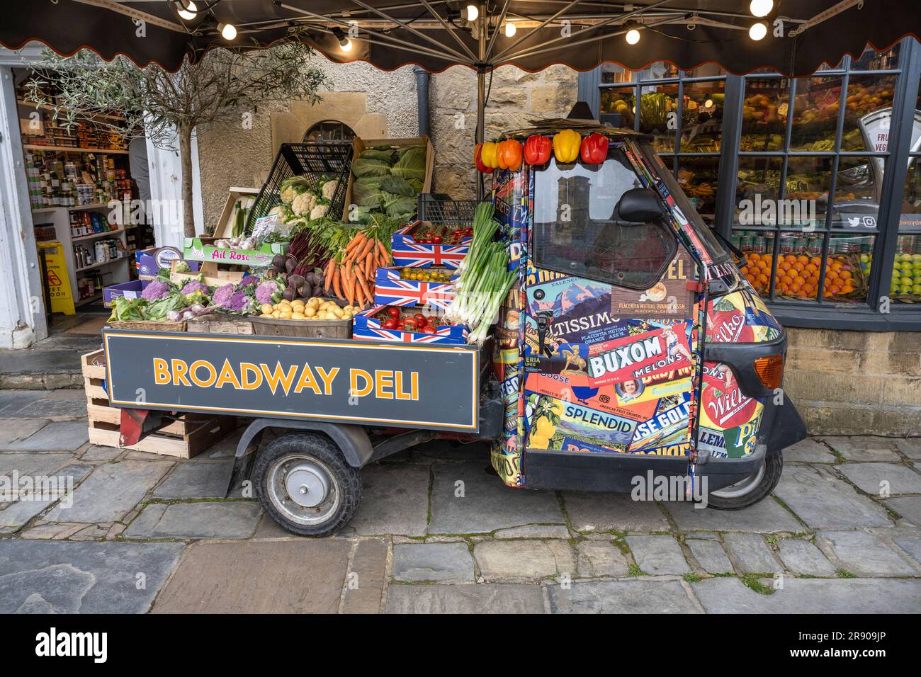 A Piaggio Ape tricycle as a vegetable stall on the high street of Broadway, Cotswolds, Worcestershire, England, United Kingdom Stock Photo