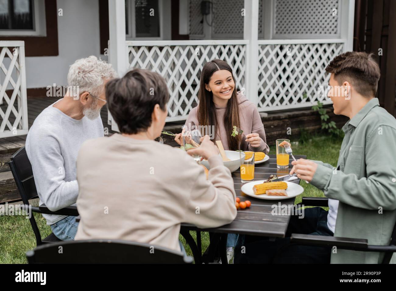 happy teenage girl looking at adutl brother during family celebration