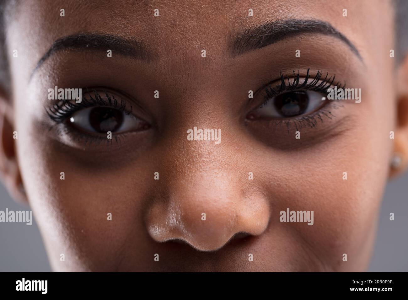 Close-up portrait of a young woman of color's eyes. Minimal depth of field, deer-like nose and eyes near. Mirror of the soul or checking for skin blem Stock Photo