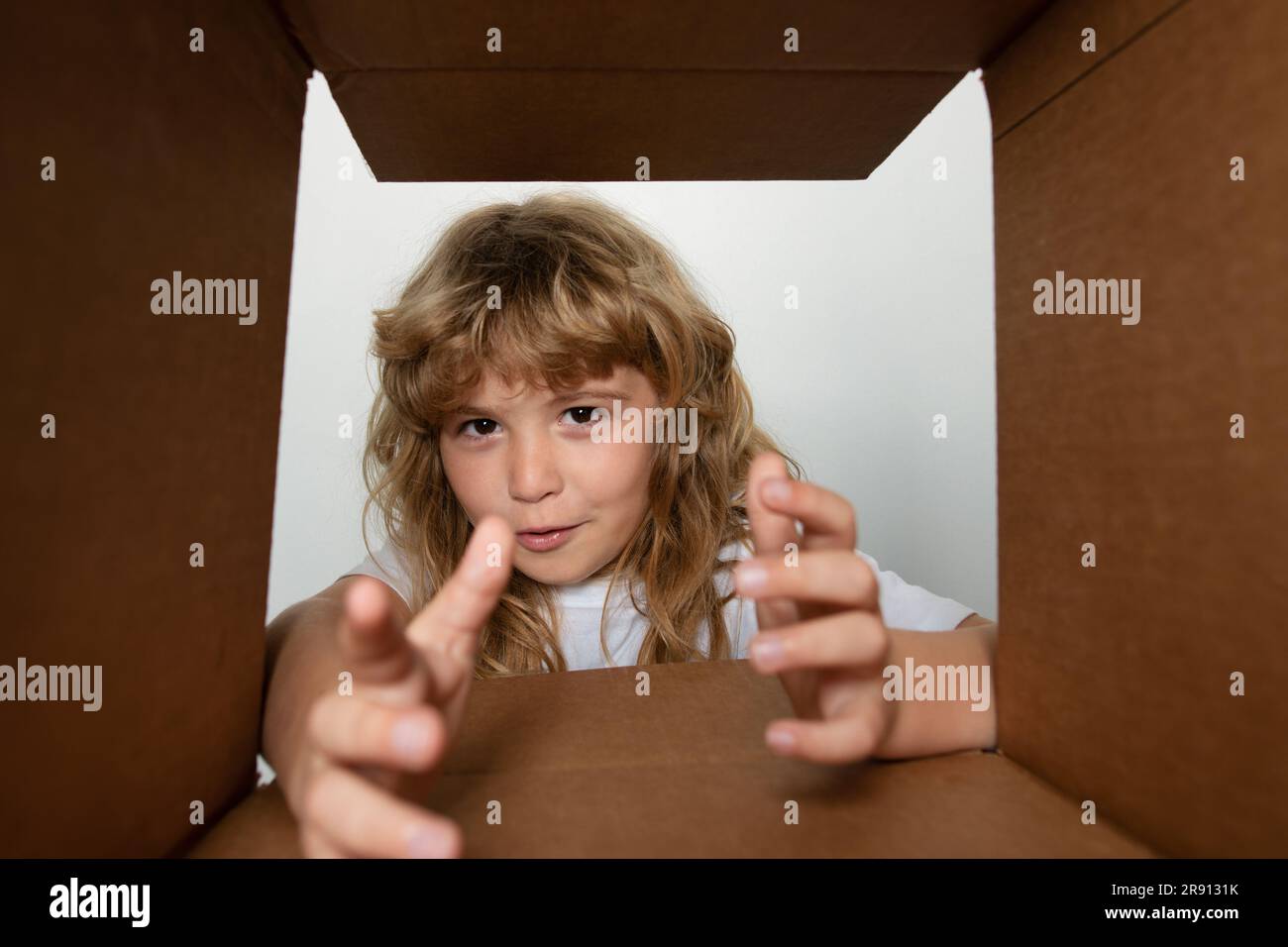 The surprised child age 8 year unpacking, opening carton box and ...
