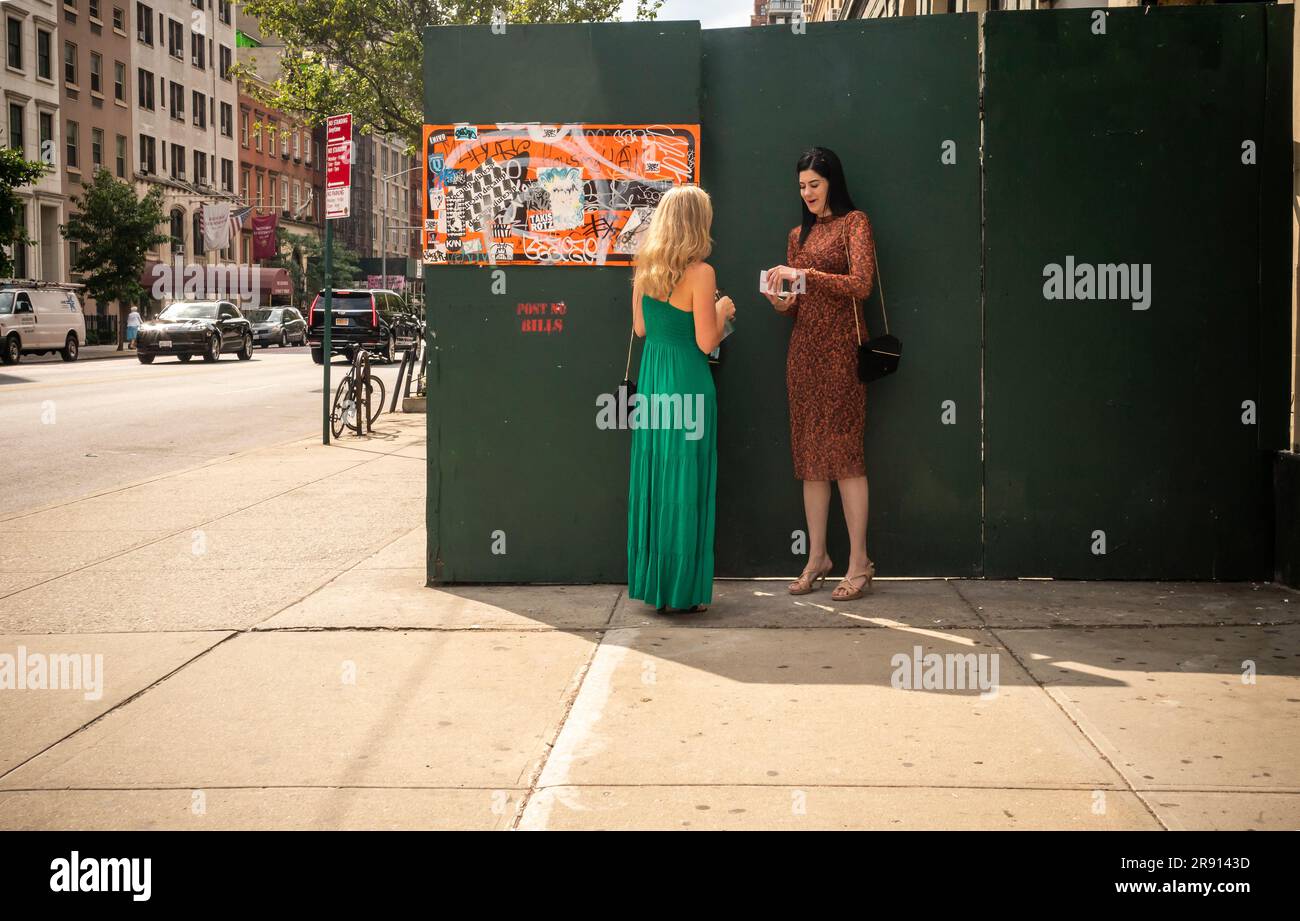 Women in front of a sidewalk shed in Chelsea in New York on Thursday, June 15, 2023. (© Richard B. Levine) Stock Photo