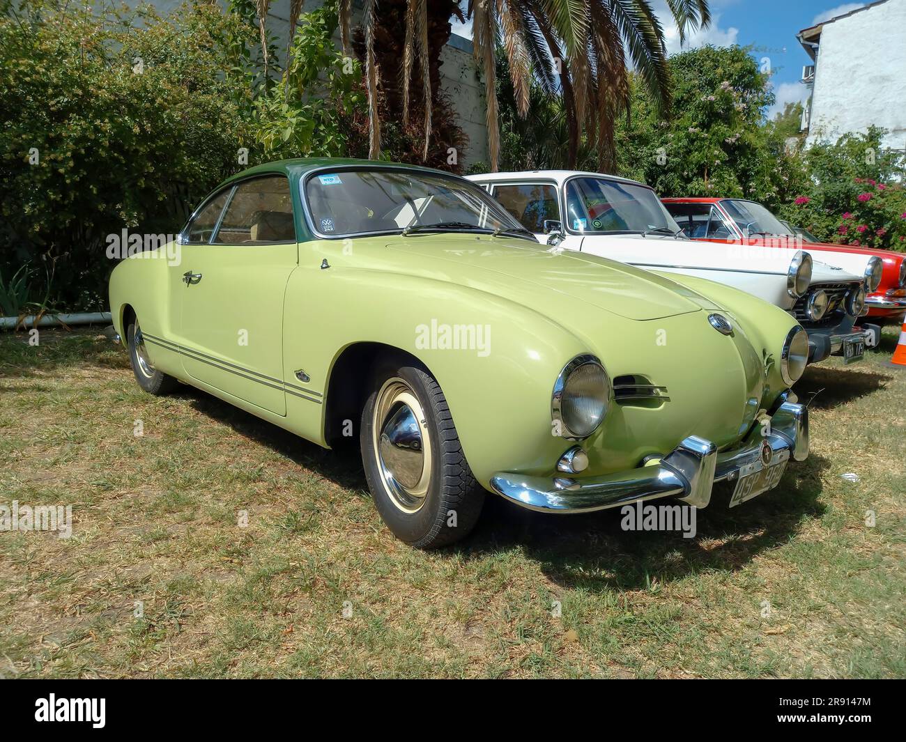 An old 1960s VW Karmann Ghia coupe in a park at the CADEAA 2023 classic