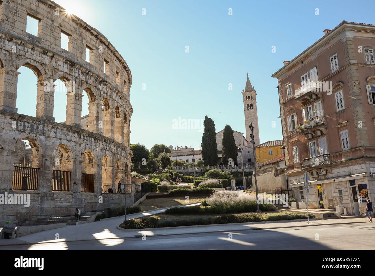 Pula, Croatia - August 21, 2022: Morning Scene of Pula Arena with Sun Rays. Roman Amphitheater with Tower and Building in Istria during Summer Day. Stock Photo