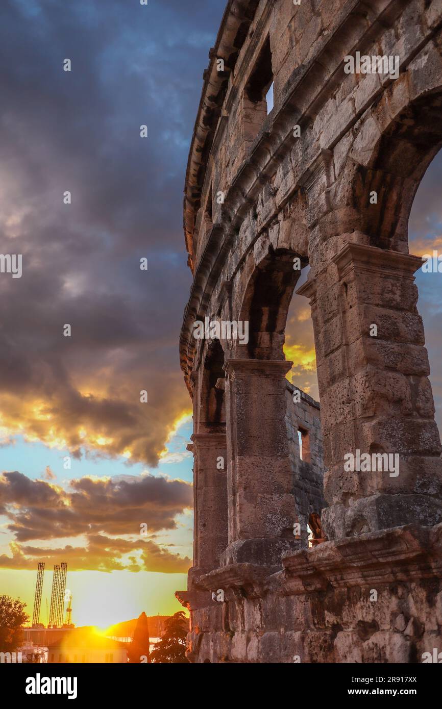 Vertical View of Pula Arena with Sunset Sun during Summer. Golden Hour Sky with Clouds and Roman Amphitheatre in Istrian Croatia. Stock Photo