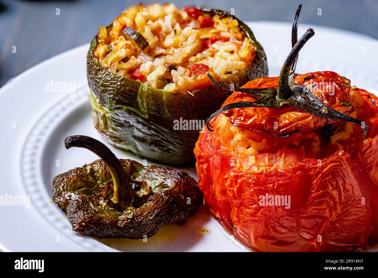 Vegan roasted tomatoes and green peppers. Close up. Stock Photo