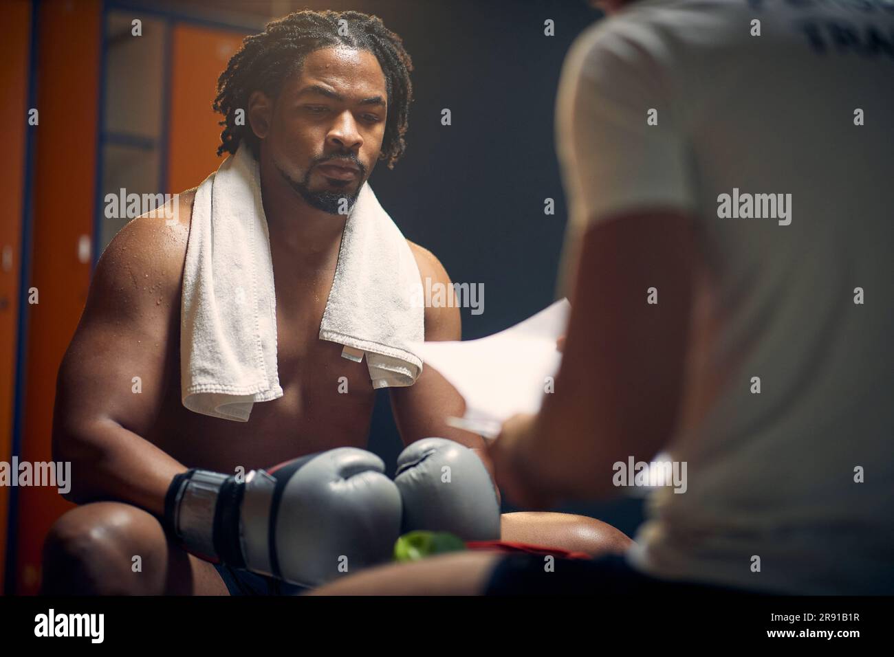 Strong muscular boxer full of sweat after boxing workout resting