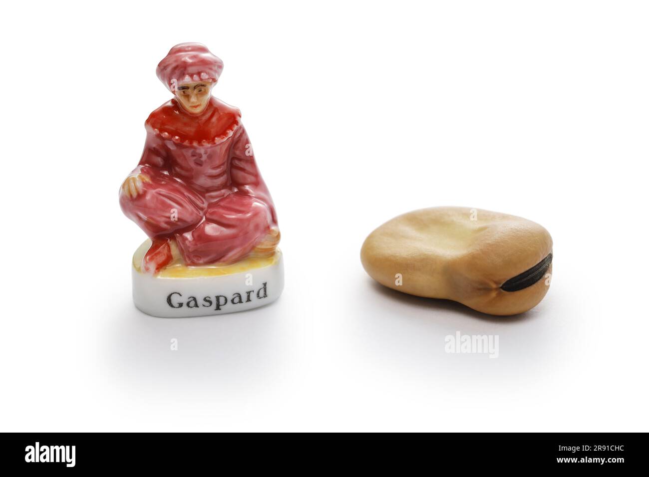small porcelain doll and broad bean to hide in Roscón de Reyes (Spanish King’s cake). Stock Photo