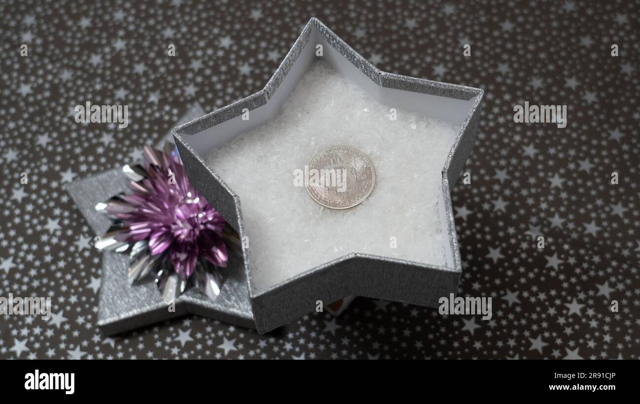 Way to give money as a gift. Giving bitcoin as a gift. A monetary gift in a  silver shiny star box, stars pattern, silver bow Stock Photo - Alamy