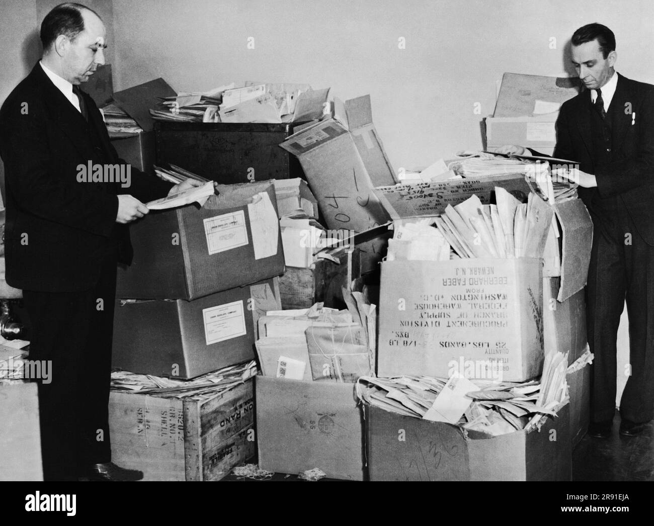Washington, D.C.:  February 13, 1936 Two members of the Interstate Commerce Commission with thousands of applications for the interstate operating of trucks and buses. Stock Photo