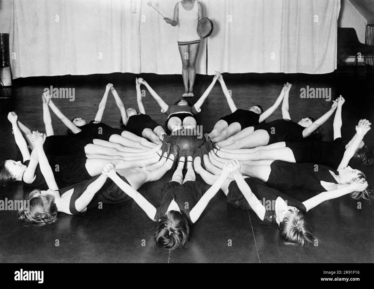 Berlin, Germany:  c. 1929 German children are given doses of artificial sunshine to improve their health. Here they are doing gymnastic exercises under what are called 'mountain sun lamps'. Stock Photo