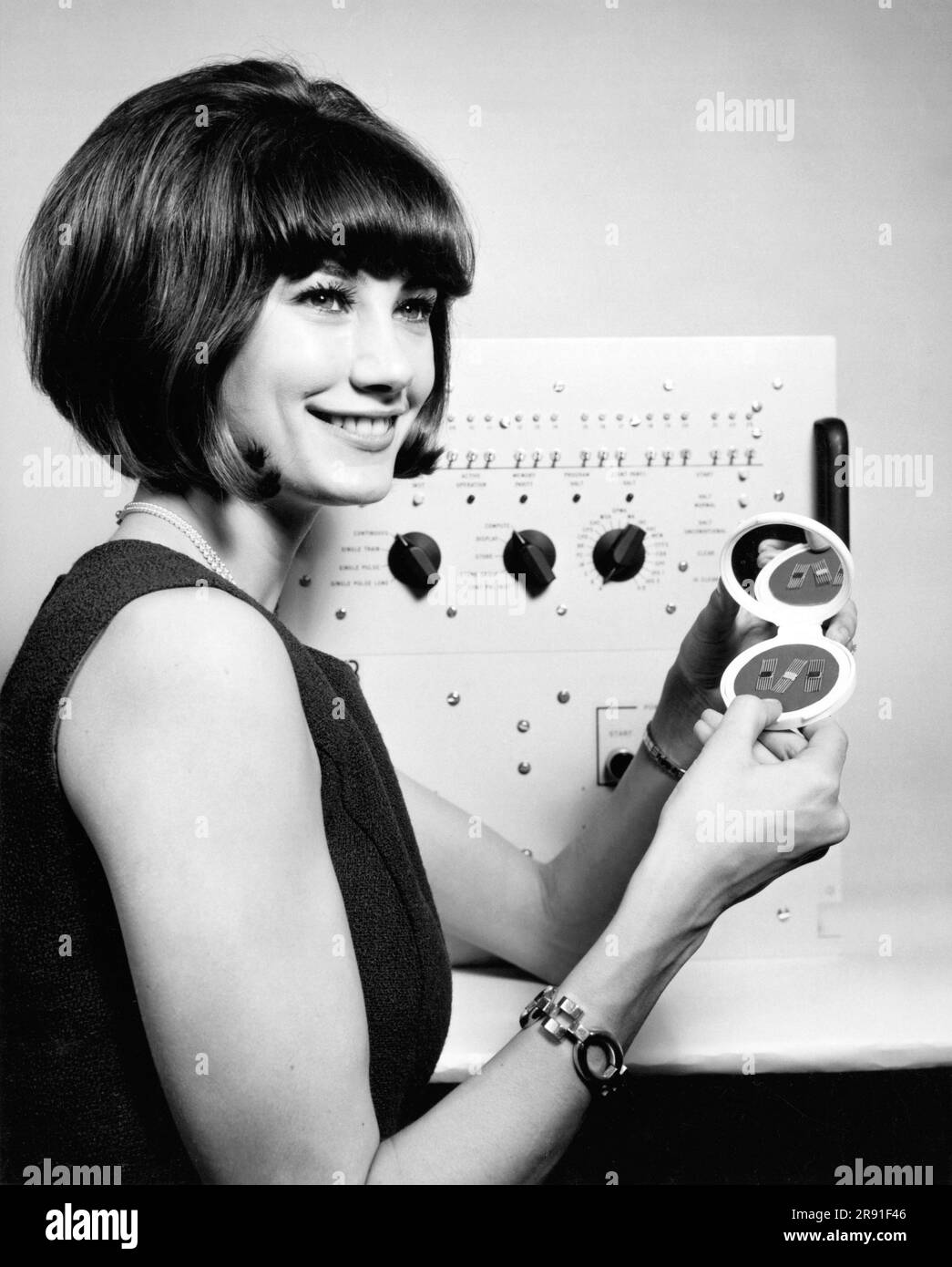 Washington, D.C.:  1965 A woman holding some of the tiny integrated circuit packages in the new Miniaturized Sylvania Processor (MSP-24). The miniature computer weighs less than 200 pounds and only occupies  four cubic feet of space. It has a main memory of 16,000 words. Stock Photo