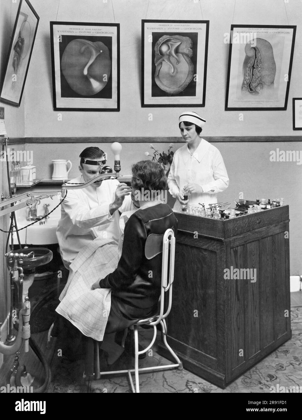 Battle Creek, Michigan c. 1927. A doctor performing a tonsil