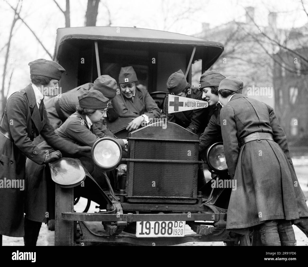 Washington, D.C.:  1920 With the flu on the increase, ambulance drivers are in demand for the American Red Cross, so here a class is being instructed in the mysteries of an ambulance motor. Stock Photo