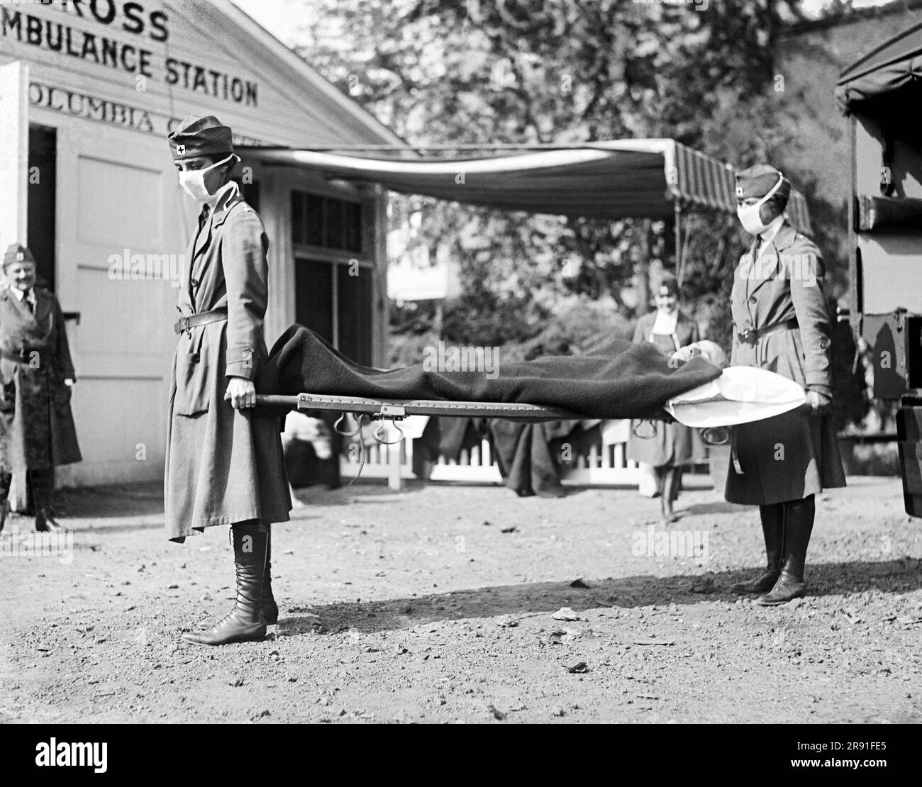 Washington, D.C.:  1918 Two Red Cross nurses with a person on a stretcher during a demonstration at the Red Cross Emergency Ambulance Station during the influenza pandemic of 1918-1920. Stock Photo