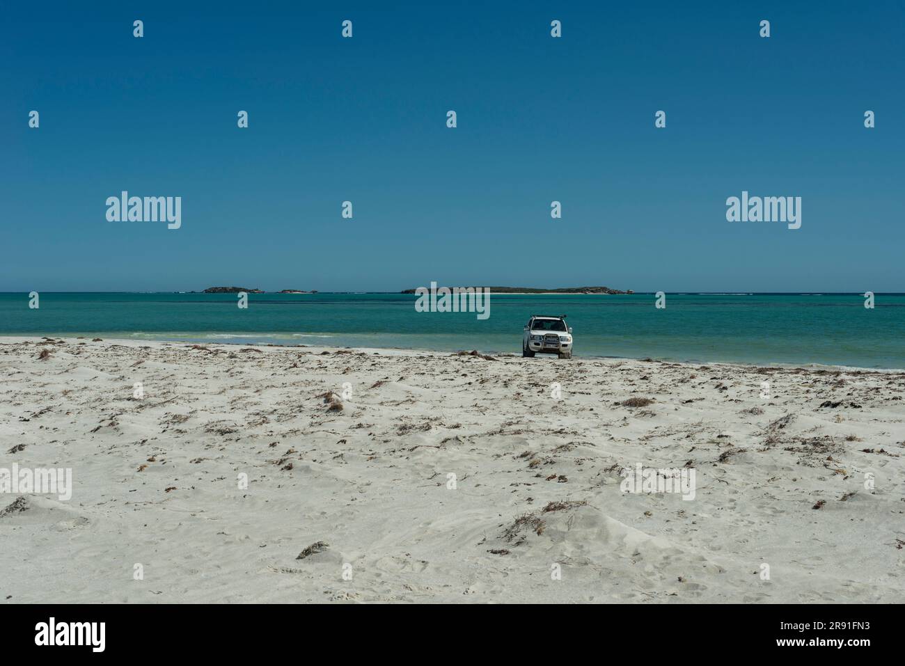 A 4wd drive vehicle is parked on the beach with the sea in the background in Western Australia Stock Photo
