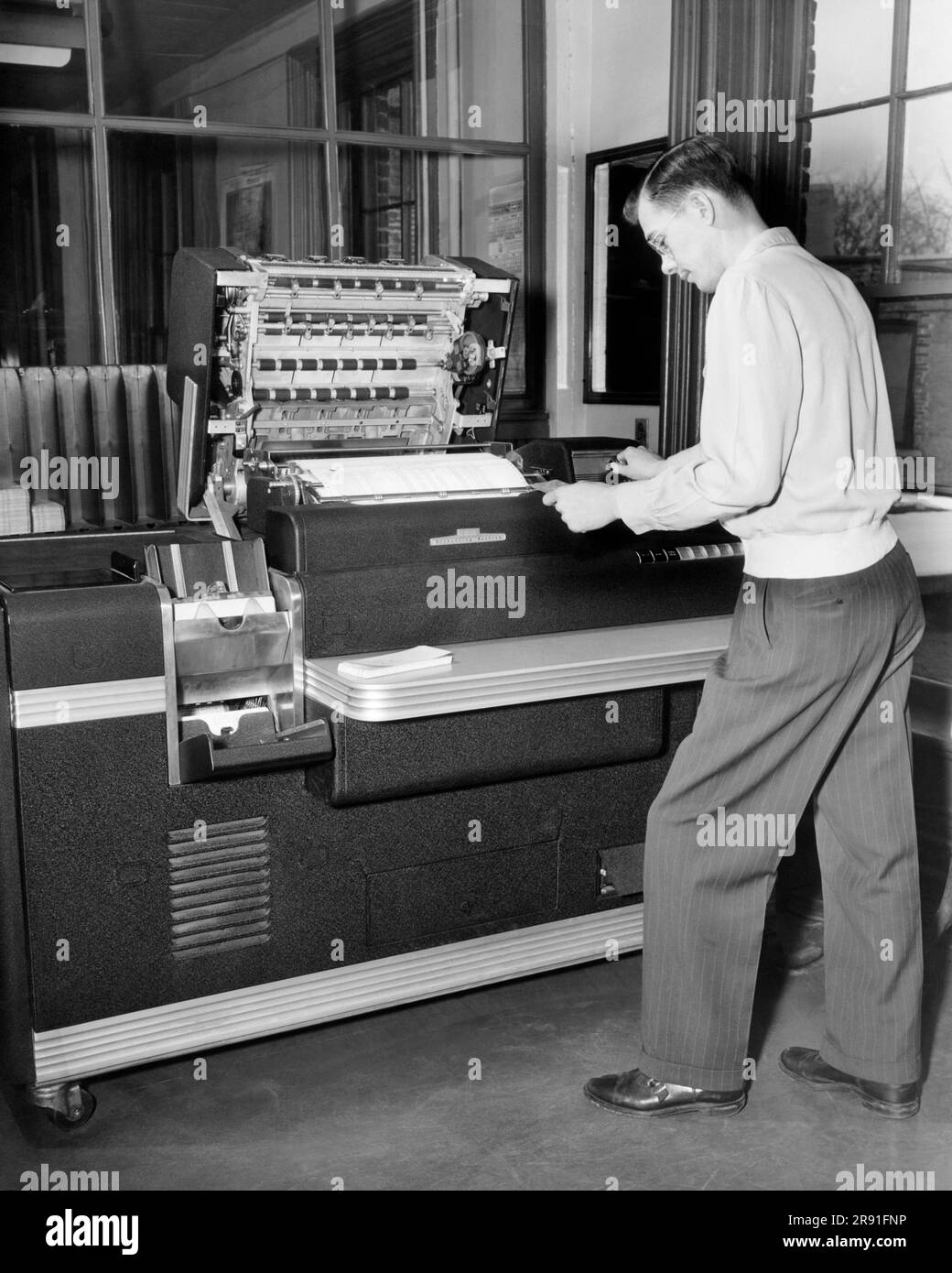 Cleveland, Ohio:  February, 1951 A worker using a large IBM Accounting Machine with punch cards at the Erie Railroad offices. Stock Photo