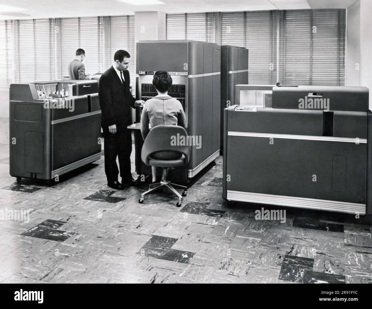 New York:  1954. A woman working at an IBM 650 Data Processing System, the first mass produced computer. IBM sold 450 of them the first year. Acessories include up to 4 disk units, each holding 6 Mb of data.. Stock Photo